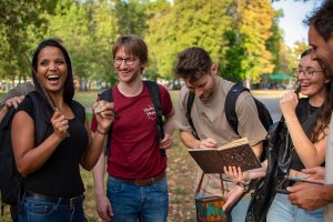 Gruppe lachend mit Zauberstab und Gegenständen